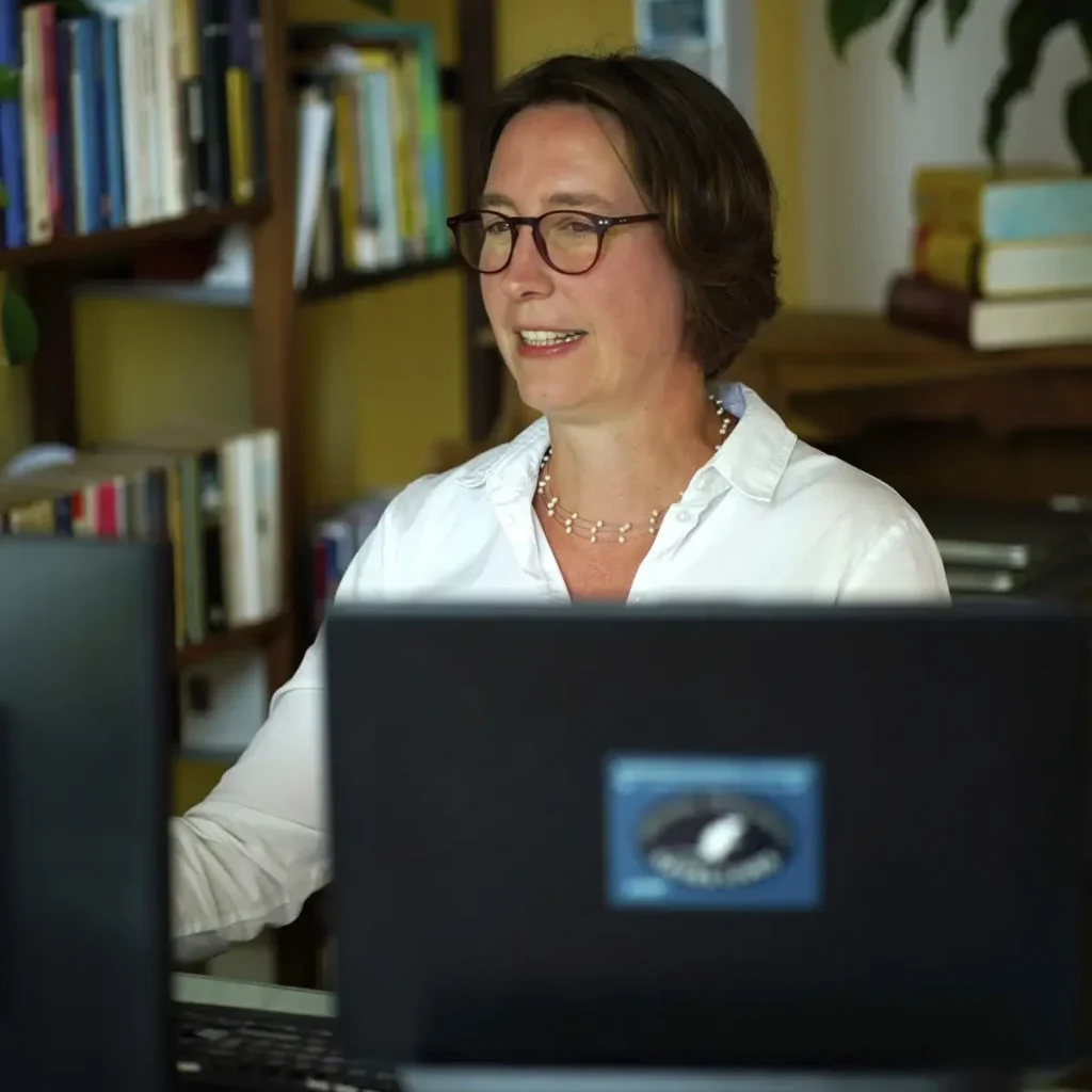 Stefanie Flunkert sitzt im Büro vor ihren Bildschirmen