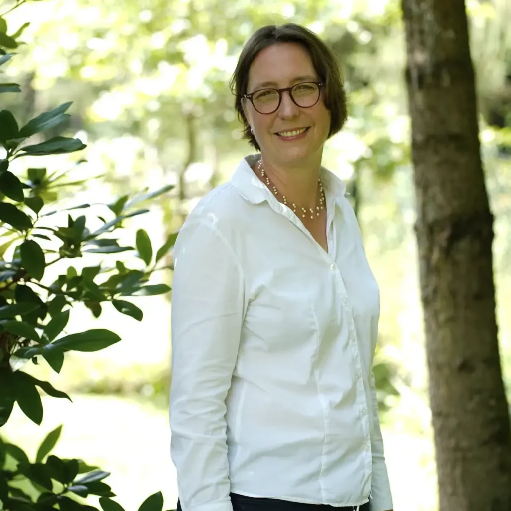 Stefanie Flunkert steht im Garten vor einem Baum