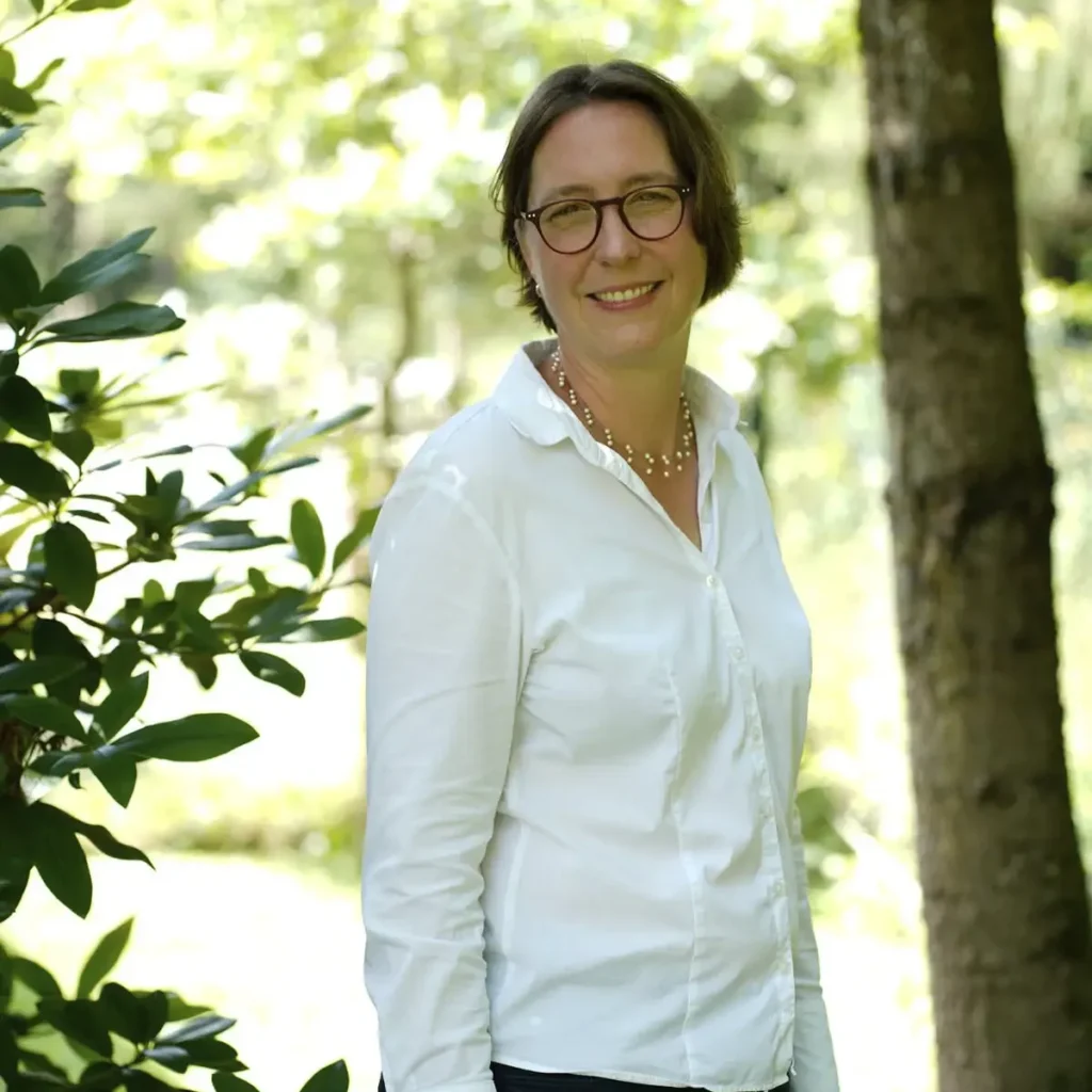 Stefanie Flunkert stands in front of a tree in the garden