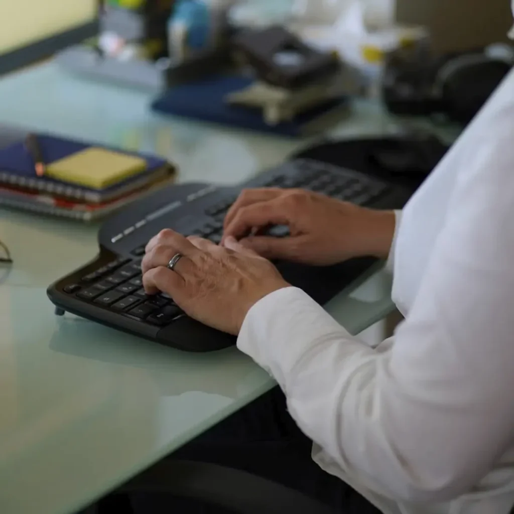 Stefanie Flunkert types on her keyboard at her office desk