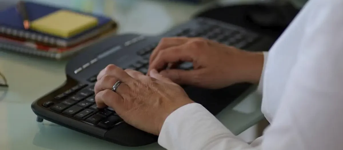 Stefanie Flunkert types on her keyboard at her office desk