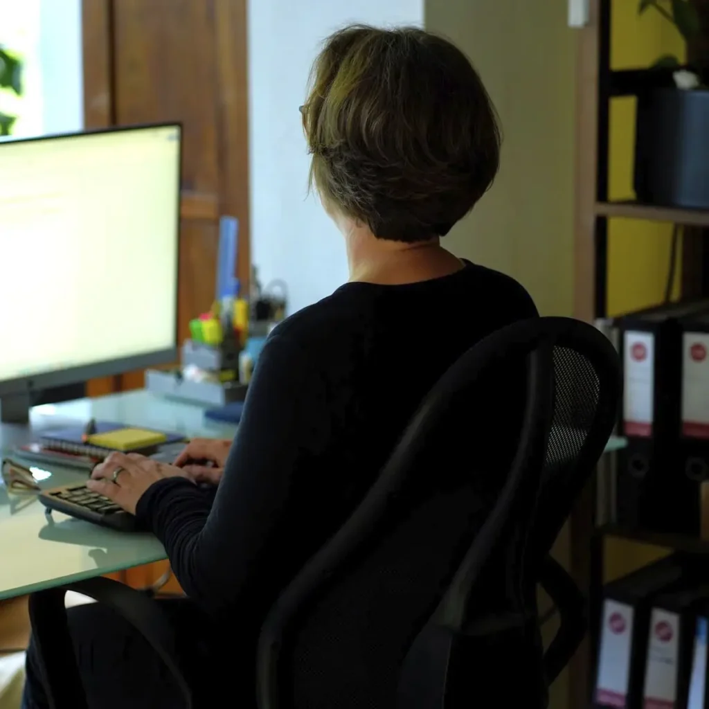 Stefanie Flunkert sits in front of her screens in the office