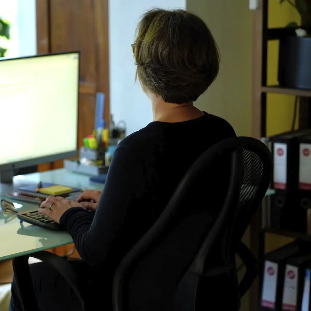 Stefanie Flunkert sits in front of her screens in the office