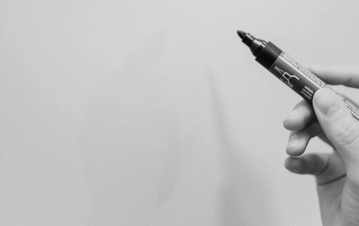 hand with pencil on white wall