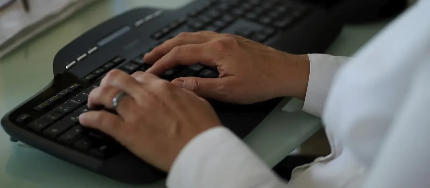 Stefanie Flunkert types on her keyboard at her office desk